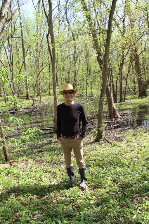 Michael stands in wetlands area home to skunk cabbage and salamanders.